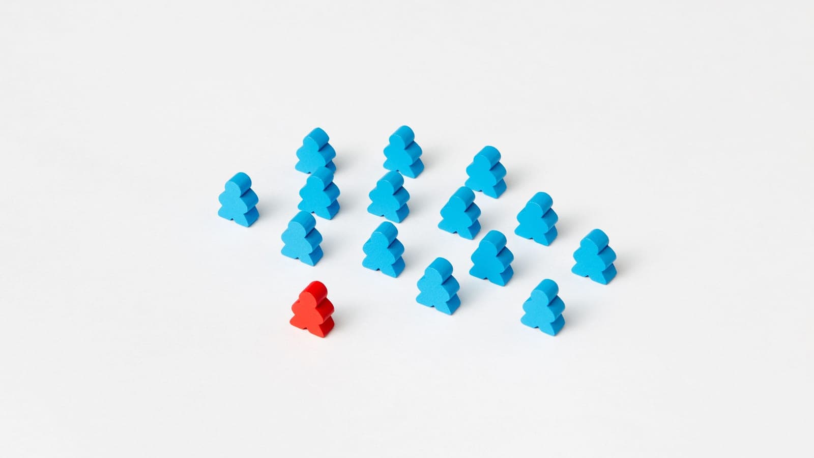 Rows of blue wooden figurines, with a single red one standing apart from the group.
